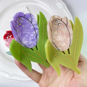 Détail de la pince à cheveux tulipe avec strass et texture en acétate marbré