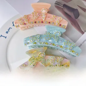 Close-up of butterfly acetate hair clips featuring intricate rhinestone embellishments