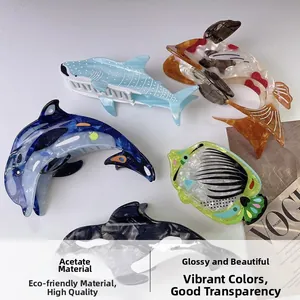 Détail des pinces à cheveux en acétate sur le thème de l'océan avec baleines
