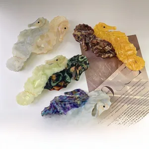 Detail von bunten Seepferdchen-Haarklammern aus Acetat mit Marmortextur auf VOGUE-Magazin