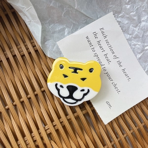 Close-up of a cute yellow acetate tiger hair clip with glossy finish for girls