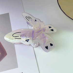 Detail of butterfly hair claw clip with pearlescent lavender finish and black heart patterns