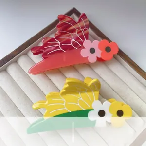 Detail of elegant acetate bee and flower hair claws with translucent texture finish