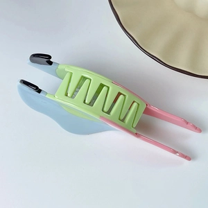 Dettaglio della pinza per capelli a pappagallo con denti in resina colorata e onde