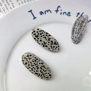 3pcs high-quality acetate hair clips with black leopard print on white ceramic dish
