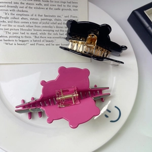Dettaglio della molletta per capelli a panda con accenti rosa e molla dorata