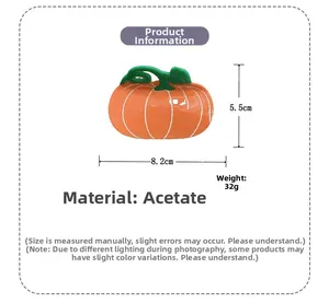 Détail de la pince à cheveux citrouille en acétate indiquant la taille 8,2x5,5cm et le poids