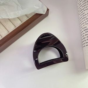 Close-up of deep purple glossy hair claw clip with minimalist hollow D-shaped design