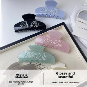 Detailed macro view of assorted acetate pearl hair claws in pastel shades with Be Be lettering