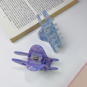 Close-up of blue and purple marble acetate butterfly hair claws with metal springs
