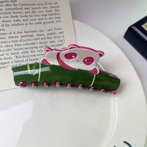 Dettaglio della molletta per capelli a panda rosa con manico a forma di bambù verde