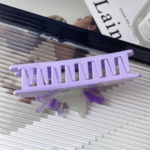 Detailed view of a purple butterfly claw clip with acetate finish on aesthetic props