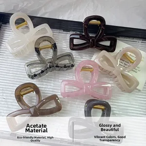 Detail of multi-colored acetate bow hair claws with durable golden metal springs