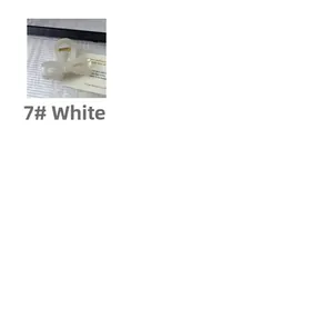 Detail view of cream white acrylic bow hair claw clip with golden metal spring