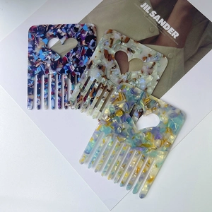 Detail of high-quality acetate hair combs featuring marble textures and heart cutouts