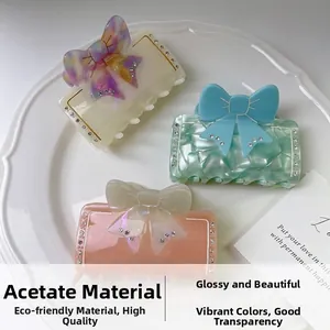 Détail de pinces à cheveux en acétate avec nœud et strass sur une assiette en céramique