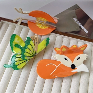 Trois pinces à cheveux en acétate avec renard orange et papillon vert sur plateau