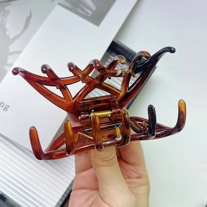 Detailed close-up of large tortoiseshell amber hair claw with strong gold metal spring