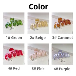 Vue détaillée de six pinces à cheveux ondulées en acétate multicolores sur présentoir