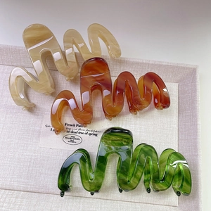 Trois pinces à cheveux ondulées en acétate coloris ambre, écaille et vert foncé