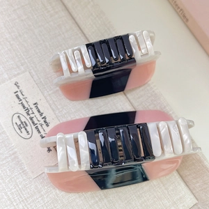 Detail of two-piece acetate claw clips set in black and pink marble patterns