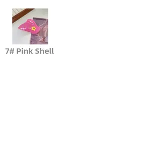 Close-up of pink conch-shaped hair claw clip with a yellow star on beach postcard