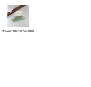 Detail view of swan-shaped acetate hair claw featuring orange goldfish and white wing patterns