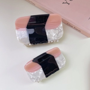 Elegant two-piece acetate hair claw clips in stylish pink, black, and marble color blocking