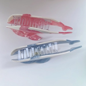 Detalle de pinzas de pelo de delfín en acetato con texturas de mármol rosa y azul