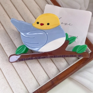 Close-up of bird on branch hair claw clip made of colorful acetate materials