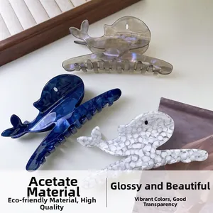 Detailed view of three acetate whale hair claws in grey, blue, and white textures