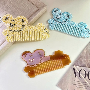 Trois peignes en acétate en forme d'ours avec motifs marbrés sur un magazine