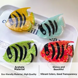 Detail of eco-friendly acetate fish-shaped hair claws with colorful marble patterns