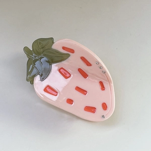 Vue détaillée de la pince à cheveux fraise douce avec strass brillants et fini crème