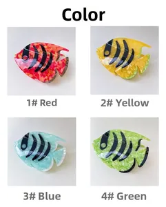 Detail of four colorful fish-shaped hair claws with marble texture and stripes