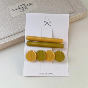Lot de trois barrettes en acétate jaune moutarde et vert olive sur carte blanche