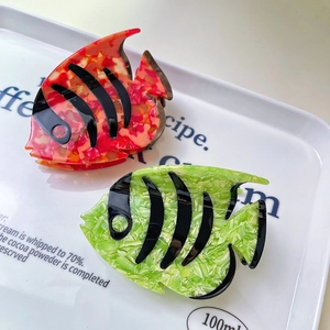 Fish-shaped marble acetate hair claws with colorful stripes and sleek marine design