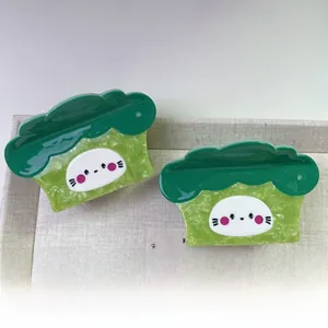 Gros plan d'une pince à cheveux en acétate en forme de brocoli vert et blanc