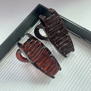 Detailed view of dual bow-shaped hair claw clips in burgundy and tortoiseshell finish