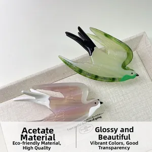 Detail showing high-quality acetate hair claws in bird shape with gradient colors
