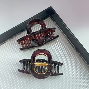 Macro shot of durable resin hair claws in amber and burgundy with strong metal springs