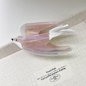 Detail of swallow hair claw clip in pink acetate with semi-transparent glossy finish