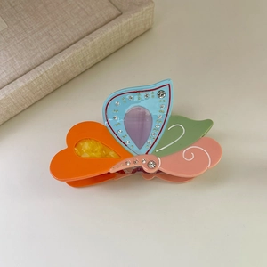 Close-up of colorful butterfly hair claw clip with rhinestones and vibrant acetate panels