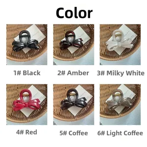 Vue détaillée des pinces à cheveux à nœud 3D en noir, ambre, crème, rouge et marron café