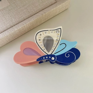 Detail showing colorful acetate butterfly hair claw clip with sparkling rhinestones