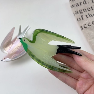 Artistic swallow-shaped acetate hair claw clip with emerald green and pearlescent pink finish