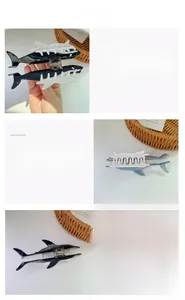 Detailed close-up of shark shaped hair claw clip showing glossy black and matte blue finish