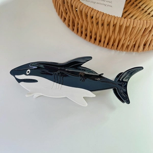 Close-up of a shark-shaped acetate hair claw clip with black and white glossy finish
