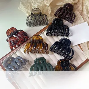 Dettaglio macro di grandi fermagli per capelli a zucca in vari colori su vassoio velluto