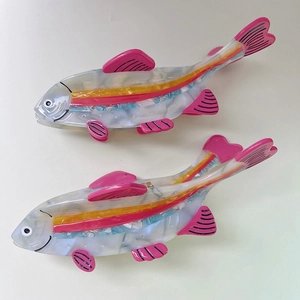 Set of two colorful fish-shaped acetate hair claws with vibrant pink fins and shell luster